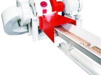 Industrial wood chipper machine with red and white components, including a feed chute and motors, ready for operation.